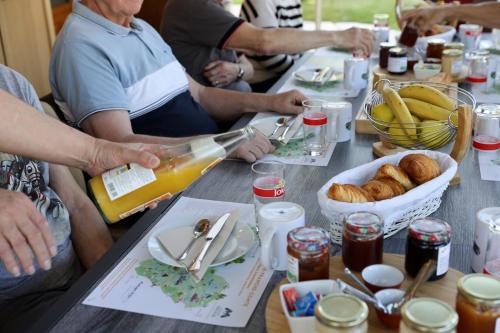 Un groupe de personnes assises autour d'une table avec de la nourriture dans l'établissement Au bon Vivant, à Dampierre-sur-Salon