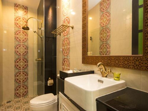 a bathroom with a sink and a toilet and a mirror at The Grand Morocc Hotel in Mae Rim