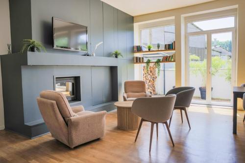 a living room with chairs and a fireplace at Gîte La Grenadine in Saint-Firmin