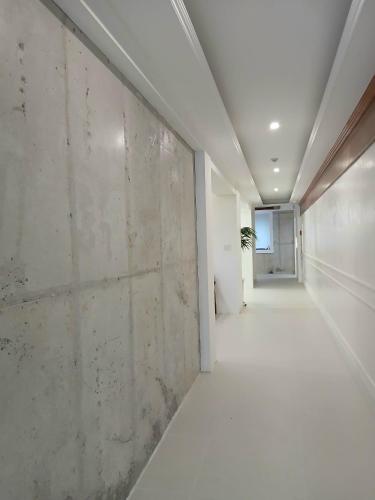 a hallway with white walls and a concrete wall at 히든힐불국사호텔 in Gyeongju