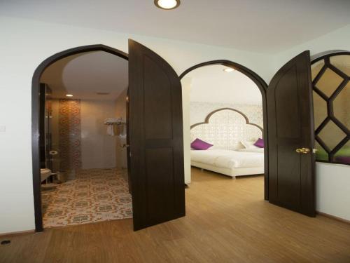 a room with a bed and two open doors at The Grand Morocc Hotel in Mae Rim