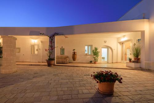 a large courtyard with potted plants in a building at Masseria Il Vignale in Ostuni