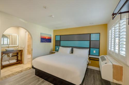 a bedroom with a large bed and a sink at Hotel Avenida Victorville I 15 in Victorville