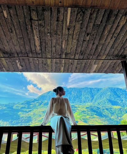 a woman looking out of a window at mountains at Táo Tày House in Sa Pa