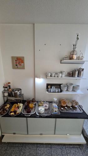 a kitchen with plates of food on a counter at Pension am Wald in Gößweinstein