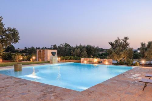 a large swimming pool in a backyard with a lit up at Masseria Il Vignale in Ostuni