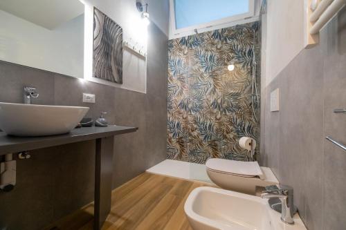 a bathroom with a sink and a toilet at Casa degli Specchi- Duplex in city center in Arona
