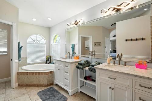 a bathroom with a tub and a sink and a bath tub at Casa in The Cove in Cape Coral
