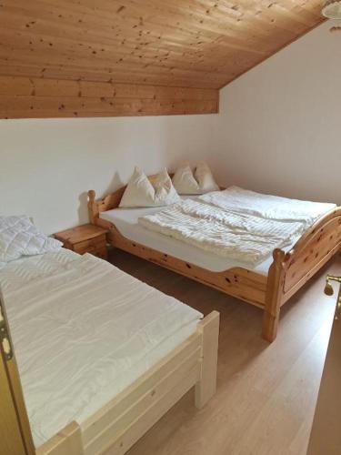 two beds in a room with wooden ceilings at Tauernbergalm in Heiligenblut