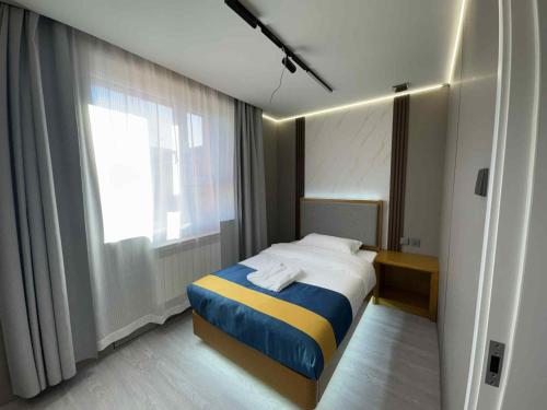 a small bedroom with a bed and a window at Yol Hotel in Dalandzadgad