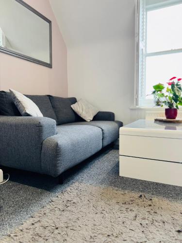 a living room with a couch and a table at Penthouse Suite, Sea View, Close to Shops, Beach and Train in St. Leonards