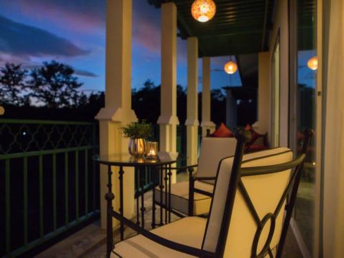 a porch with chairs and a table at night at The Grand Morocc Hotel in Mae Rim