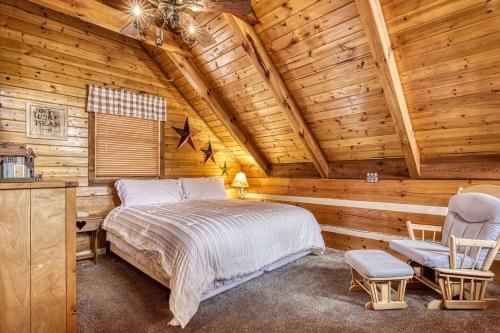 ein Schlafzimmer mit einem Bett in einer Blockhütte in der Unterkunft Laceys Place By Beyond Expectations W Hot Tub in Sevierville