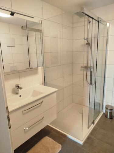 a white bathroom with a shower and a sink at Wohnung im Grünen in Mitterdorf im Mürztal
