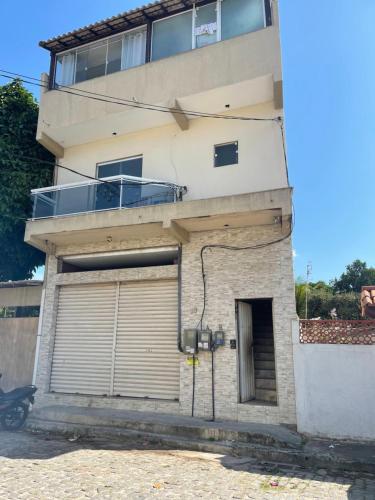 an apartment building with a garage and a balcony at Loft Cantinho do Amor in Rio das Ostras