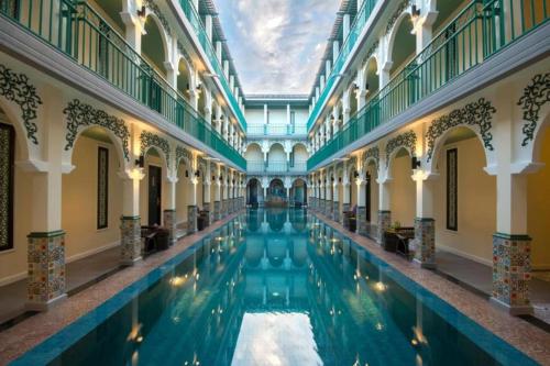 an indoor swimming pool in a building with water in it at The Grand Morocc Hotel in Mae Rim