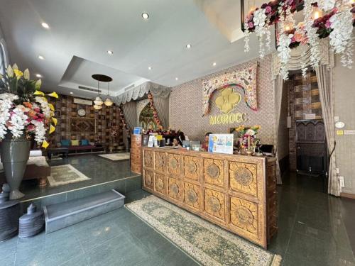 a restaurant with a counter with flowers on the wall at The Grand Morocc Hotel in Mae Rim