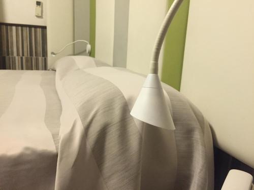 a bedroom with a bed with a white comforter at Hotel Flavia in Rome