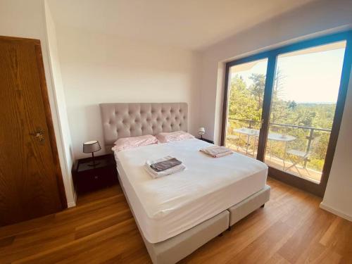 a bedroom with a large bed and a large window at Helles Apartment Bergblick Nähe Messe Frankfurt in Bad Soden am Taunus