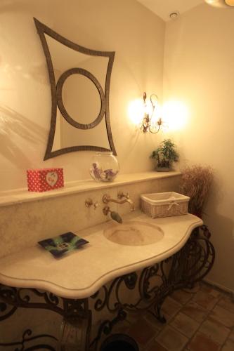 a bathroom with a sink and a mirror on the wall at Mas Loisonville - Demeure d'exception & Spa en Drôme Provençale in Grillon