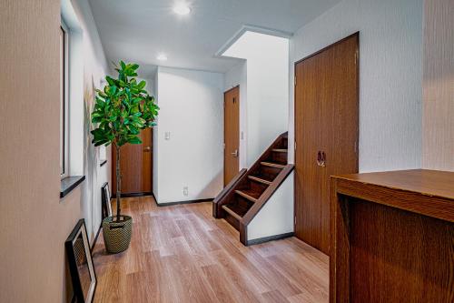 a hallway with a staircase and a potted plant at 南9西20戸建 in Sapporo