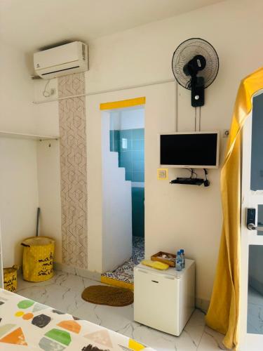 a room with a tv on the wall and a bed at Grace house jacuzzi in Saly Portudal