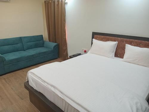 a bedroom with a large bed and a couch at Hotel Devinn Begusarai in Begusarai