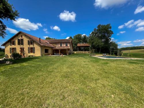 a large yard in front of a house at Maison Puchouaou Gîte 8 ou 12 personnes avec piscine privée in Montesquiou
