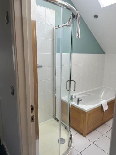 a bathroom with a shower and a sink and a tub at 5A Retallack Resort & Spa in Saint Columb Major