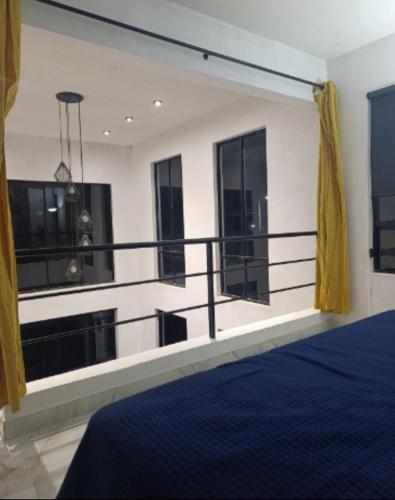 une chambre avec un balcon avec des rideaux jaunes dans l'établissement Loft Céntrico Cedral, à Cedral