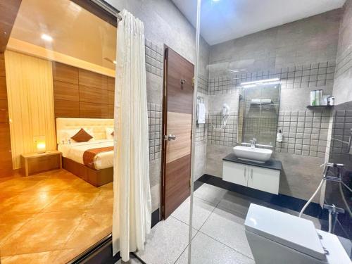 a bathroom with a bed and a sink and a toilet at Nova Grand Canyon in Cochin