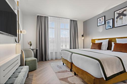 a hotel room with a large bed and a window at Leonardo Hotel Mainz in Mainz