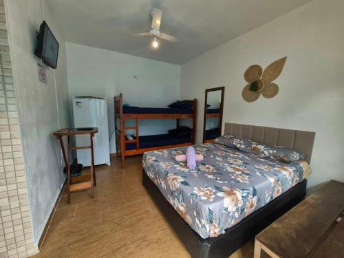 Schlafzimmer mit einem Bett, einem Tisch und einem Ventilator in der Unterkunft Hospedagem Econômica Flor de Maria 2 in Caraguatatuba