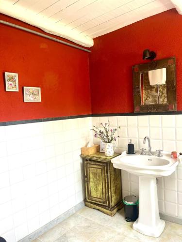a bathroom with a sink and a red wall at Casa Valle Verde in Brugnato