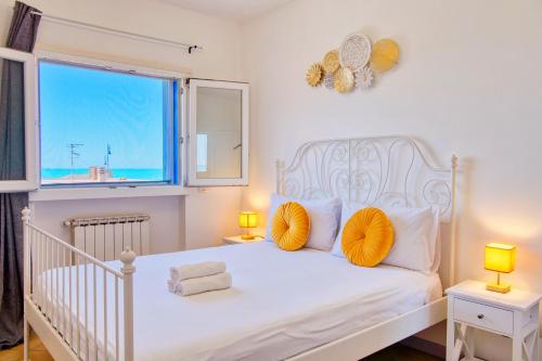 フィウミチーノにあるBeach Vista Apartment, Fiumicinoのベッドルーム(白いベッド、黄色い枕付)