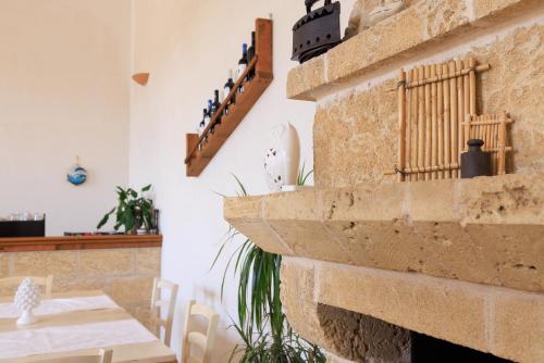a room with a stone fireplace and a table and chairs at Masseria Il Vignale in Ostuni