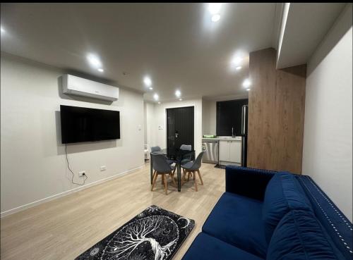 a living room with a blue couch and a table at Two Bedrooms With Two Bathrooms in Hamilton