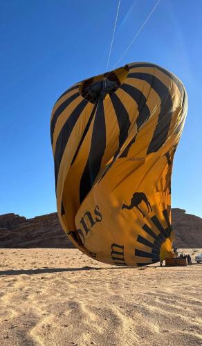 un grande aquilone giallo e nero seduto sulla sabbia di Celestial Mirage Camp a Wadi Rum