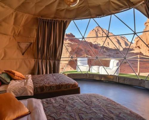 pokój z dwoma łóżkami i widokiem na pustynię w obiekcie Celestial Mirage Camp w mieście Wadi Rum