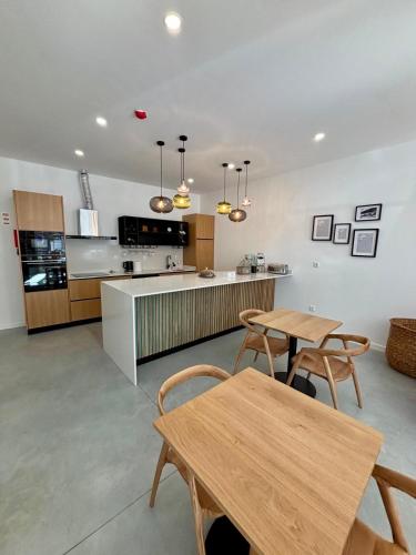 a kitchen with two wooden tables and a counter at Casa Tawny in Pinhão