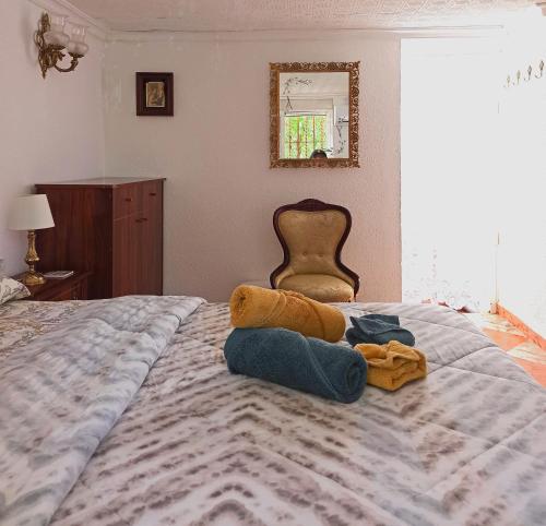 1 dormitorio con 1 cama con manta y silla en El Azahar, en Sevilla