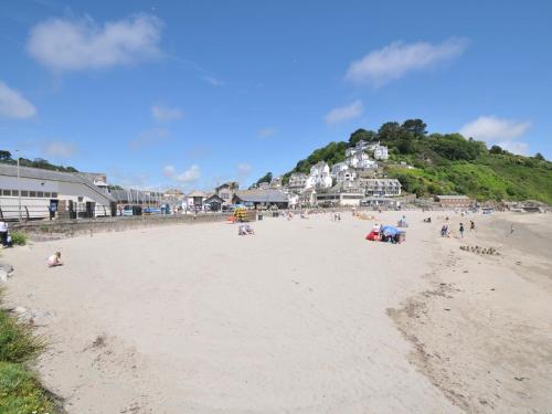 a group of people on a sandy beach at Evelyn in Looe