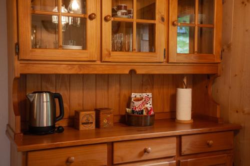 a wooden cabinet with a coffee maker on a counter at Casa Cantone Devero-baita storica con balcone e giardino, posizione comoda e soleggiata- spazio biciclette in Alpe Devero
