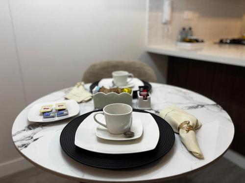 a table with two cups and plates on it at Apartamento en Miraflores in Lima