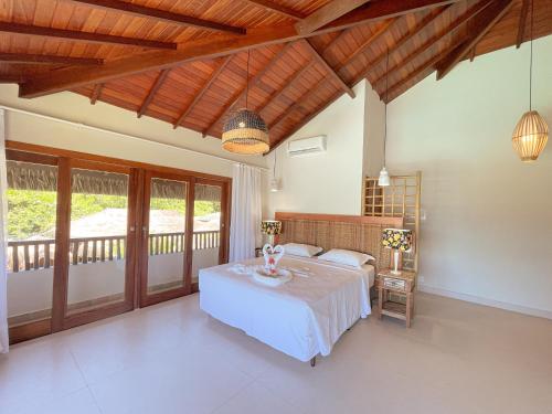 a bedroom with a bed and a balcony at Hotel Espelho D'Água Arraial e Beach Club in Arraial d'Ajuda