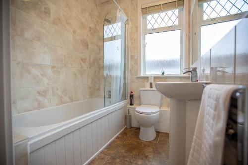a bathroom with a toilet and a tub and a sink at Cosy City Home from home! in Portsmouth