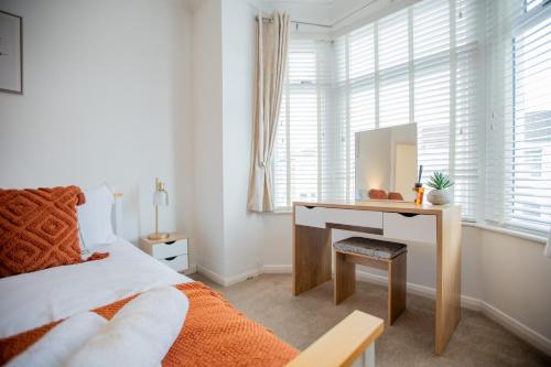 a bedroom with a desk and a bed with a mirror at Cosy City Home from home! in Portsmouth