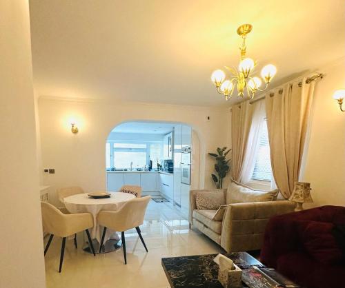 a living room with a table and a couch at The Robin - Luxury 2 Bedroom apartment with garden and parking in Greater London in Orpington