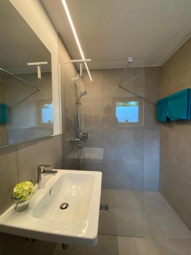 a bathroom with a white sink and a shower at Neueröffnung! Gästezimmer im Herzen von Lauterach in Lauterach