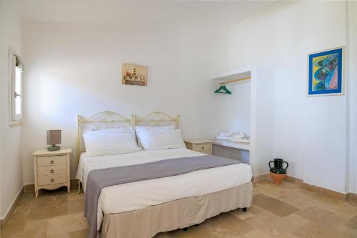 a bedroom with a bed with white sheets and pillows at Masseria Il Vignale in Ostuni